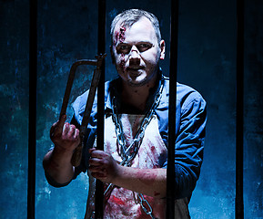 Image showing Bloody Halloween theme: crazy killer as butcher with electric saw