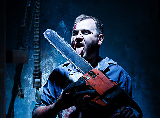 Image showing Bloody Halloween theme: crazy killer as butcher with electric saw