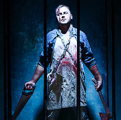 Image showing Bloody Halloween theme: crazy killer as butcher with electric saw