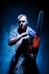 Image showing Bloody Halloween theme: crazy killer as butcher with electric saw