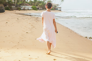 Image showing Woman walking on the beach sand