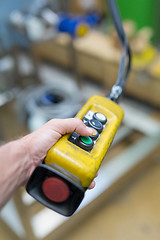 Image showing Industrial worker pushing on button of machinery controler.