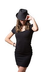 Image showing Joyful pretty girl wearing black dress and classic hat smiling at camera. Beauty, fashion concept. Isolated white background