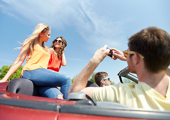 Image showing friends driving in car and photographing