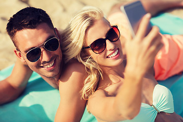 Image showing happy couple in swimwear walking on summer beach