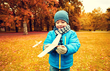 Image showing happy little boy playing with toy plane outdoors