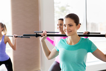 Image showing group of happy women with bars exercising in gym