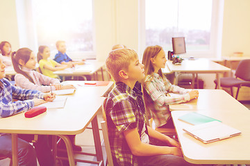 Image showing group of school kids with notebooks in classroom