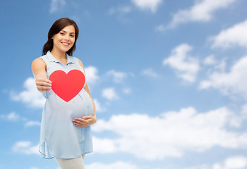 Image showing happy pregnant woman with red heart touching belly