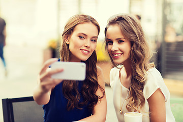 Image showing happy women with smartphone taking selfie at cafe
