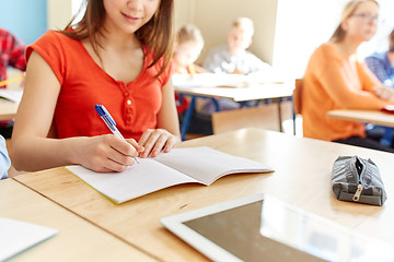 Image showing close up of student writing to notebook at school