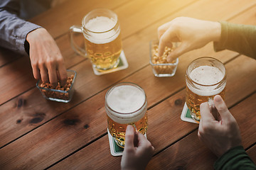 Image showing close up of hands with beer mugs at bar or pub