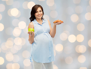 Image showing happy pregnant woman with apple and croissant