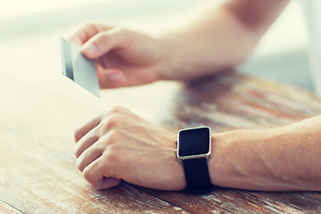Image showing close up of hands with smart watch and credit card