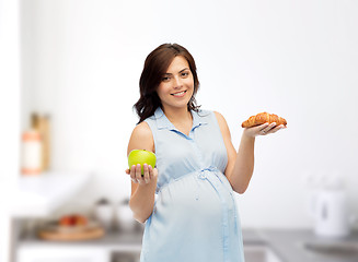 Image showing happy pregnant woman with apple and croissant