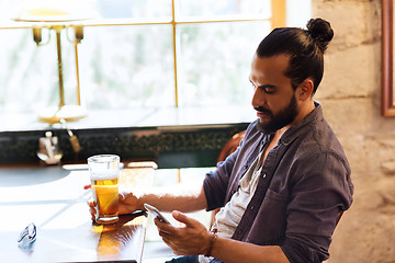 Image showing man with smartphone drinking beer at bar or pub