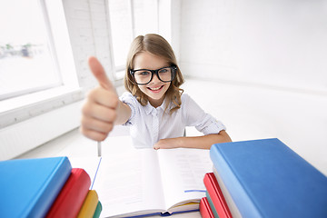 Image showing happy school girl with books showing thumbs up