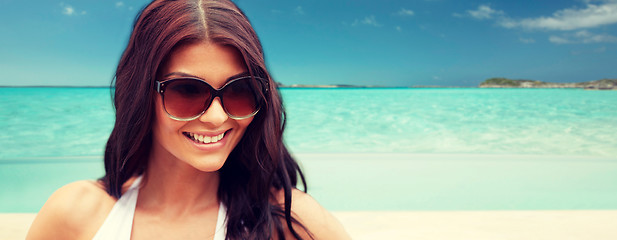 Image showing smiling young woman with sunglasses on beach