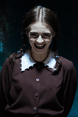 Image showing Portrait of a young smiling girl in school uniform as killer woman