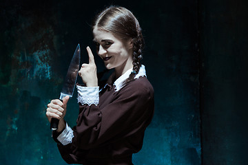 Image showing Portrait of a young girl in school uniform as killer woman