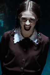Image showing Portrait of a young smiling girl in school uniform as killer woman
