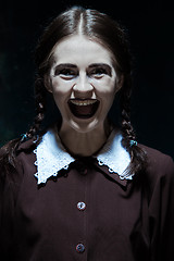 Image showing Portrait of a young smiling girl in school uniform as killer woman