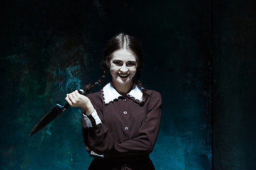 Image showing Portrait of a young girl in school uniform as killer woman