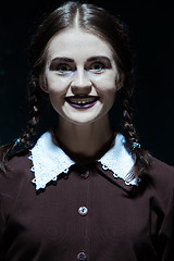 Image showing Portrait of a young smiling girl in school uniform as killer woman