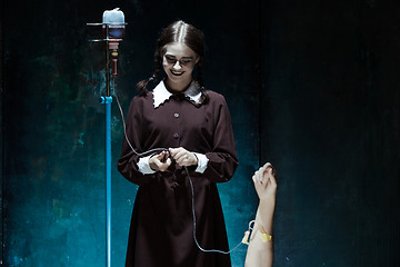 Image showing Portrait of a young girl in school uniform as killer woman