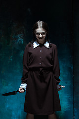 Image showing Portrait of a young girl in school uniform as killer woman