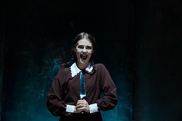 Image showing Portrait of a young girl in school uniform as killer woman