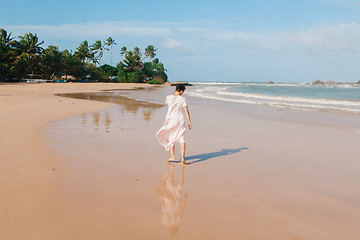 Image showing Woman legs walking on the beach sand