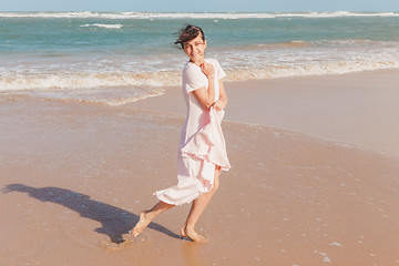 Image showing Woman legs walking on the beach sand