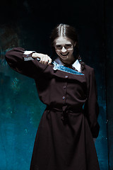 Image showing Portrait of a young girl in school uniform as killer woman