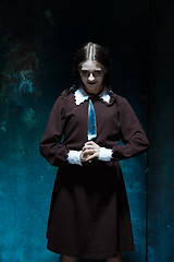 Image showing Portrait of a young girl in school uniform as killer woman