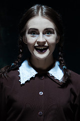 Image showing Portrait of a young smiling girl in school uniform as killer woman