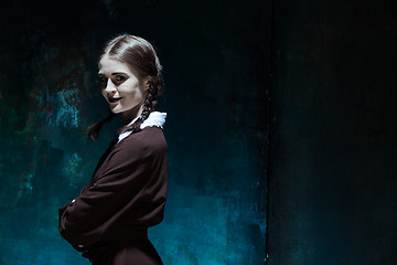 Image showing Portrait of a young smiling girl in school uniform as killer woman