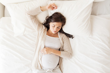 Image showing happy pregnant woman sleeping in bed at home