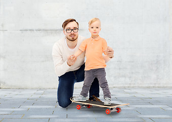 Image showing happy father and little son on skateboard