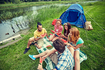 Image showing happy friends eating watermelon at camping