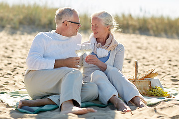 Image showing happy senior couple having picnic on summer beach