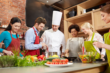 Image showing happy friends and chef cook cooking in kitchen