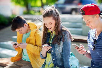 Image showing happy teenage friends with smartphones outdoors