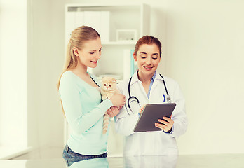 Image showing happy woman with cat and doctor at vet clinic