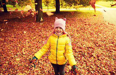 Image showing happy girl playing with autumn leaves in park