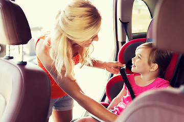 Image showing happy mother fastening child with car seat belt