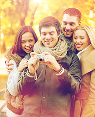 Image showing group of friends with photo camera in autumn park