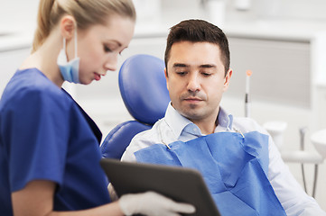 Image showing female dentist with tablet pc and male patient