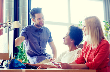 Image showing happy creative team with computer in office