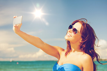 Image showing happy woman with phone on the beach